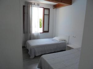 a bedroom with two beds and a window at Villa Tord Massot 11 in Ciutadella