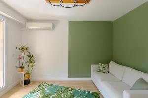 a living room with green walls and a white couch at Le Clos de Vallaurias in Vallauris