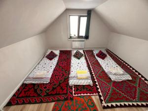 an attic room with two tables and a window at Taldy-Suu Guesthouse in Taldysu