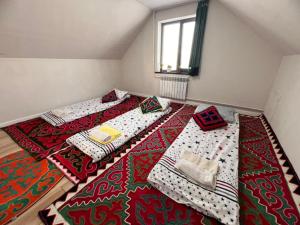 a room with two twin beds on a rug at Taldy-Suu Guesthouse in Taldysu +32 photos