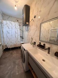 a bathroom with a sink and a washing machine at Taldy-Suu Guesthouse in Taldysu