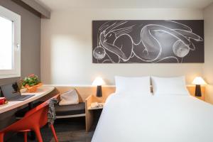 a hotel room with a bed and a desk and a chair at ibis Dieppe Le Val Druel in Dieppe