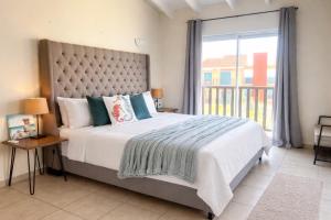 a bedroom with a large bed and a large window at Palapa Beach Resort Curacao in Jan Thiel +150 photos