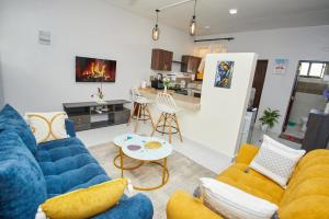 a living room with blue couches and a kitchen at Diani Dream stays in Diani Beach