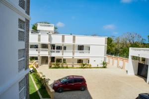 a red car parked in front of a white building at Diani Dream stays in Diani Beach