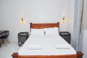 a bedroom with a large bed with two night stands at Diani Dream stays in Diani Beach