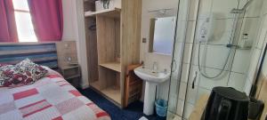 a bathroom with a bed and a sink and a shower at Marine View in Brighton & Hove +65 photos