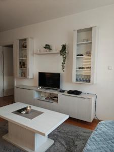 a living room with a table and a tv at Urban escape in Doboj