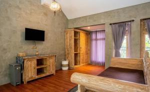 a bedroom with a bed and a flat screen tv at Juminten Villa in Ubud