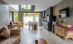 a kitchen and living room with a couch and a table at Juminten Villa in Ubud