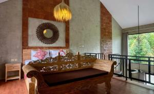 a living room with a couch and a mirror at Juminten Villa in Ubud