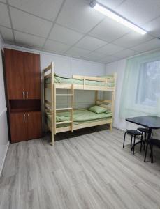 a room with bunk beds and a table in it at Ліза in Irpin +5 photos