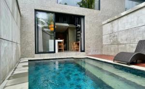 a swimming pool in front of a house at Juminten Villa in Ubud