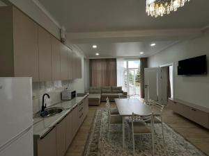 a kitchen with a table and chairs and a living room at Royal Beach Cottage Issyk Kul in Chok-Tal