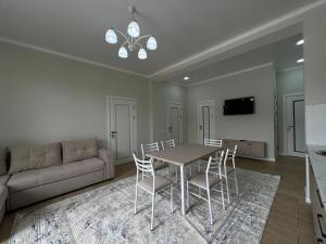a living room with a table and chairs and a couch at Royal Beach Cottage Issyk Kul in Chok-Tal