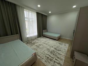 a bedroom with a bed and a window and a rug at Royal Beach Cottage Issyk Kul in Chok-Tal