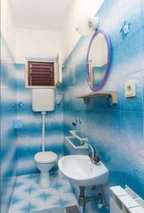 a blue tiled bathroom with a toilet and a sink at Primošten-Huljev in Primošten