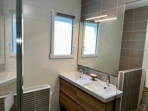 a bathroom with a sink and a mirror at Le Relais du 49 - Gîte in La Séguinière