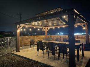 a table and chairs under a pavilion at night at Villa Hello Fujisan ヴィラハローフジサン 屋根付きBBQ場 ワンちゃん大歓迎 A220 in Fujiyoshida