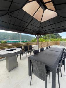 a table and chairs under an umbrella on a patio at Villa Hello Fujisan ヴィラハローフジサン 屋根付きBBQ場 ワンちゃん大歓迎 A220 in Fujiyoshida