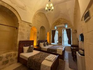 a hotel room with two beds and a desk at Helen Olimpos Konağı in Mardin