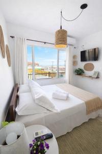 a bedroom with a large bed and a large window at Pousada Surf na Guarda in Guarda do Embaú +18 photos