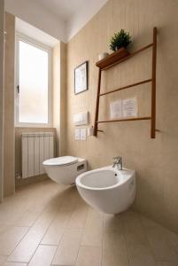a bathroom with two sinks and a toilet and a window at Casa aMare in Chioggia