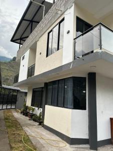 a large white building with a yellow hose at Boutique Exclusive Stay in Baños