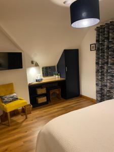 a bedroom with a bed and a chair and a table at The Well Bed & Breakfast in Clonakilty