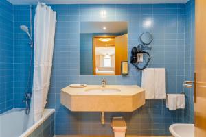 a blue tiled bathroom with a sink and a mirror at Cascais Hotel in Cascais +60 photos