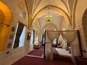 a bedroom with a bed in a building with a chandelier at Helen Olimpos Konağı in Mardin