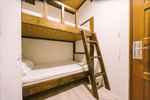 two bunk beds in a room with a ladder at 許家古宅 4-6人包棟民宿 依訂購人數給房間 寵物友善 需清潔費 in Tainan