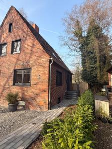 a brick house with a wooden walkway in front of it at Fewos Herrentor in Emden in Emden