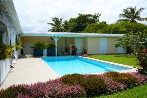 a swimming pool in the yard of a house at Villa Créoléna - Chambres d'hôtes avec piscine - option kitchenette - proche plage - calme absolu - Nord Grande-Terre in Anse-Bertrand