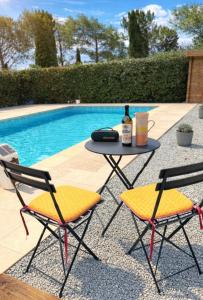 a table and two chairs next to a swimming pool at Villa Côte & Provence - private heated pool in Fayence