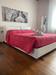 a bedroom with a bed with a red blanket at L'Albero della Vita in Sinalunga