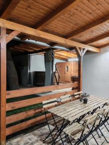a wooden patio with chairs and a wooden table at Bakonyi Vénkörte Vendégház in Bakonypéterd