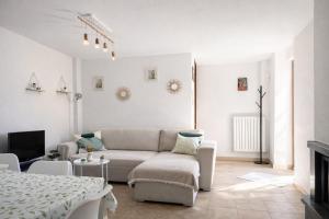 a white living room with a couch and a table at Apartment Cà Dai Noni - Family & Pet Friendly - Terrace - Near Lake Maggiore in Feriolo