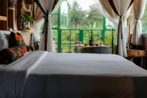a bed sitting in a room with a window at Mount Kilimanjaro 360 view Cottage in Uru