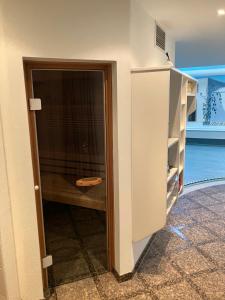 a room with a door into a room with a cabinet at Landhaus am Bach in Sulzberg