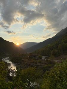 a sunset over a river in a valley with mountains at Bar-Restaurant-Hotel River in Këlcyrë Fshat