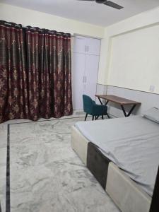 a bedroom with a bed and a table and a chair at Gitanjali luxury in New Delhi
