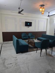 a waiting room with blue chairs and a tv at Gitanjali luxury in New Delhi