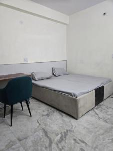 a bed in a room with a desk and a chair at Gitanjali luxury in New Delhi
