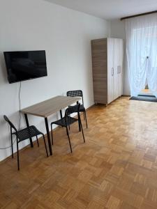 a room with a table and two chairs and a television at Berghülen Zimmer in Berghülen