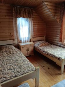 a bedroom with two beds in a log cabin at Вілла Олекси in Skhidnitsa