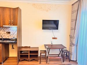 a kitchen with a table and a tv on the wall at Nasip House in Istanbul