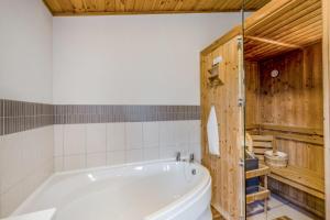 a bathroom with a white tub and wooden walls at Field View 1 bed-No Pets-Cedar in Eye +9 photos