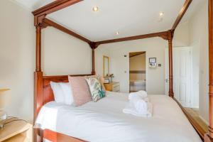 a bedroom with a large white bed with wooden posts at Field View 1 bed-No Pets-Cedar in Eye