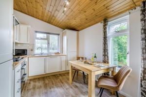 a kitchen with white cabinets and a wooden ceiling at Field View 1 bed-No Pets-Cedar in Eye